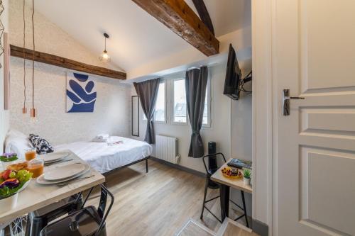 Cette petite chambre comprend un lit et une table avec de la nourriture. dans l'établissement WS Saint-Lazare - Lafayette, à Paris