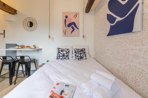 Cette petite chambre comprend un lit blanc et un mur. dans l'établissement WS Saint-Lazare - Lafayette, à Paris