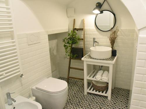 a white bathroom with a sink and a toilet at A Casa di Costanza in Atri