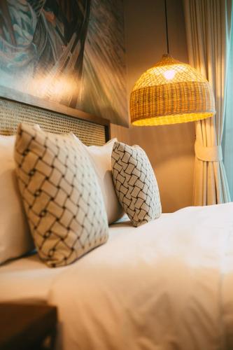 a bedroom with a bed with two pillows and a lamp at BARA BARA' Budget SATUN 'SHA Plus' in Satun