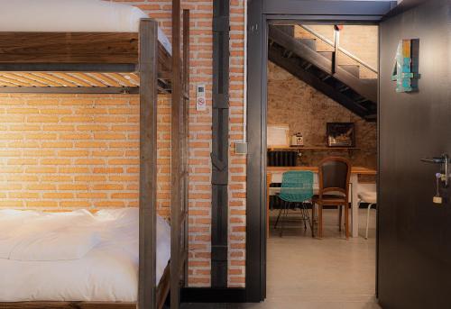 een slaapkamer met een bakstenen muur en een stapelbed bij LaNave in Madrid