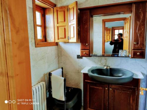 a person taking a picture of a bathroom sink at Albergueria Frade in O Cebrero
