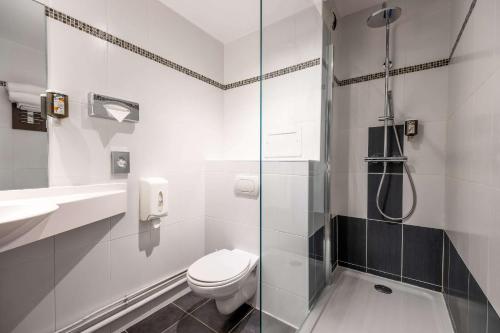 La salle de bains est pourvue de toilettes et d'une douche en verre. dans l'établissement Comfort Hotel Clermont Saint Jacques, à Clermont-Ferrand