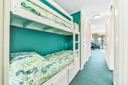 1 dormitorio con 2 literas y pared azul en Casa Del Mar Beachfront en Galveston