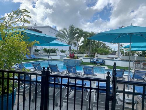 a resort pool with chairs and umbrellas at Inn On Fifth in Naples