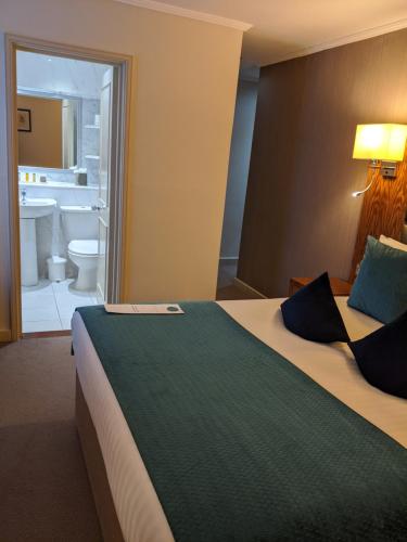 a hotel room with a bed and a desk at Cotswold Lodge Hotel in Oxford