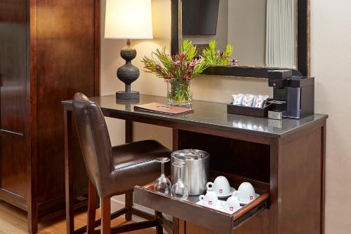 a wooden table topped with a coffee mug and a vase at L'Auberge De Sedona in Sedona