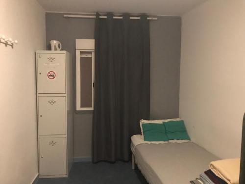 Habitación pequeña con cama y cortina en Ceibo Ibiza - Guest House en Ibiza