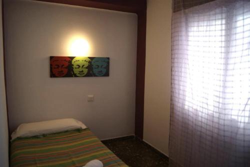 Zimmer mit einem Bett und einer Lampe an der Wand in der Unterkunft Ceibo Ibiza - Guest House in Ibiza-Stadt