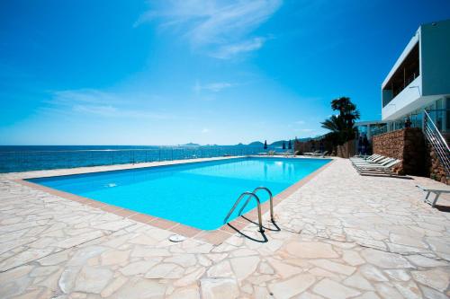 een zwembad met uitzicht op het water bij Hôtel Cala di Sole in Ajaccio