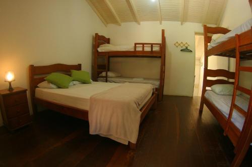 a bedroom with two bunk beds and a room with at Pousada Tubes Maresias in Maresias