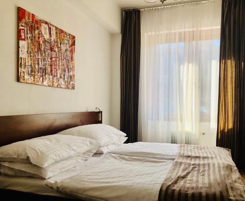 a bedroom with a bed with a window and a bedspread at Hotel & Penzión Grand Matej in Banská Štiavnica