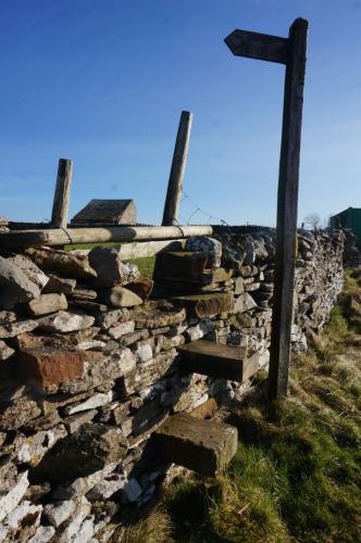 a stone wall with a cross on top of it at High Greenside in Kirkby Stephen