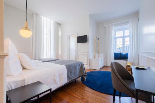 a bedroom with a bed and a blue rug at CASA DA GRAÇA in Ponta Delgada