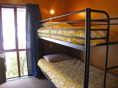 two bunk beds in a room with a window at Alpine Cabin - Ohakune Holiday Home in Ohakune