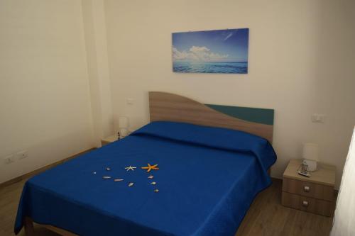 a bedroom with a blue bed with gold stars on it at Appartamenti AcquaChiara in San Vito lo Capo