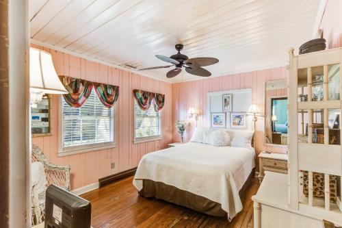 Schlafzimmer mit einem Bett und einem Deckenventilator in der Unterkunft Clervue Cottage in Folly Beach