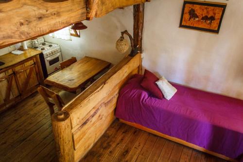 a bedroom with a bed and a table in it at Cabañas Las Moras in Tandil