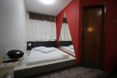 um pequeno quarto com 2 camas e um telefone em Motel Strattus (Adults Only) em Belo Horizonte