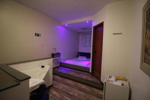 um quarto com uma cama com luzes roxas em Motel Strattus (Adults Only) em Belo Horizonte