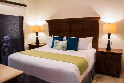 1 dormitorio con 1 cama grande con almohadas azules y verdes en El Faro 206 Reef, en Playa del Carmen