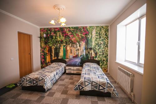 クングルにある"Гостевой дом "Relax"の壁に絵画が飾られた部屋のベッド2台