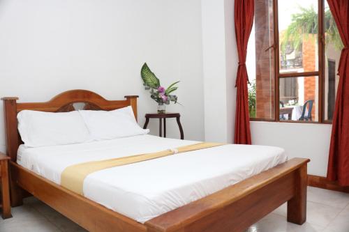 sypialnia z łóżkiem i oknem w obiekcie Hotel Colonial - Honda - w mieście Honda