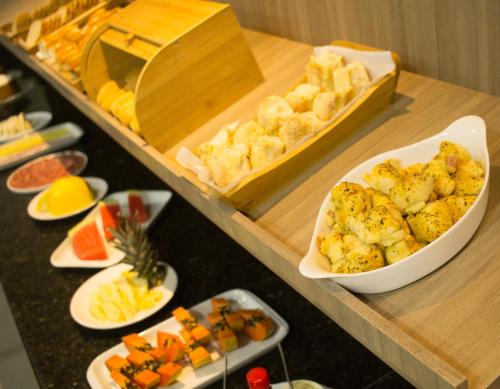 a buffet with various appetizers and fruits on a table at Hotel Marjaí in Itajaí