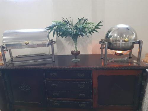 a wooden dresser with a glass bowl and a plant on it at PEDRA BONITA PRECIOSO HOTEL ltda in Itaboraí