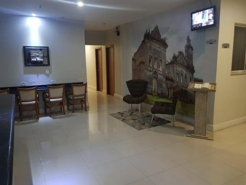 una sala de espera con sillas y una pintura en la pared en PEDRA BONITA PRECIOSO HOTEL ltda, en Itaboraí