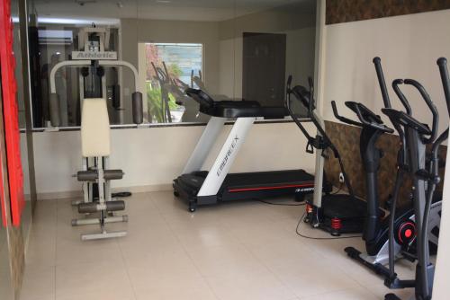 einen Fitnessraum mit Laufband und Crosstrainern in einem Zimmer in der Unterkunft Maximus Business Hotel in Ji-Paraná
