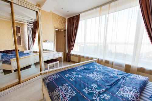a bedroom with a bed and a large window at Sun City Apart Hotel in Dnipro