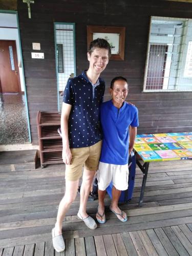 two young men posing for a picture on a porch at AA Homestay in Mulu