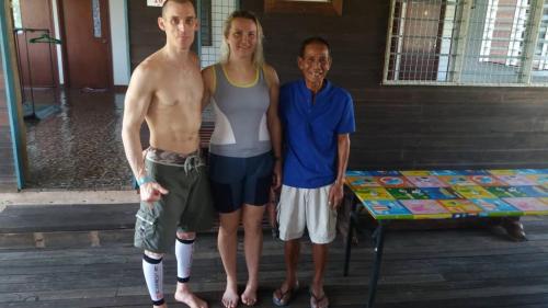 two men and a woman posing for a picture at AA Homestay in Mulu