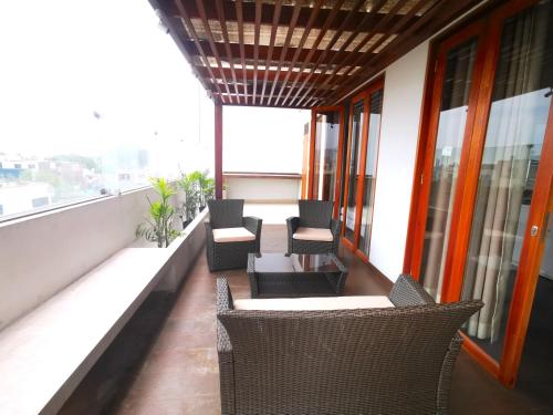 a balcony with chairs and tables on a building at Residencial Cafferata in Lima