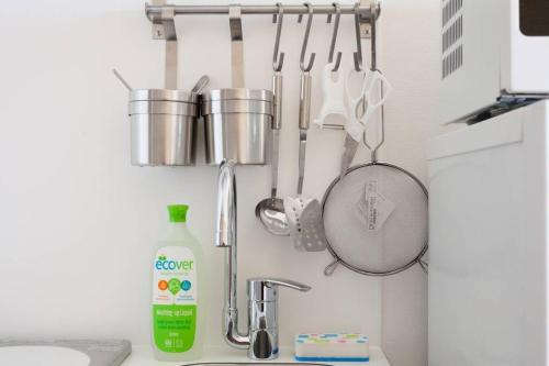 a kitchen with a sink and utensils on the wall at Dwell Urban 6C in Tokyo