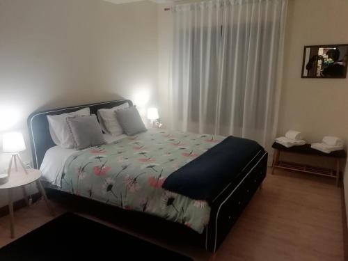 a bedroom with a bed with a floral comforter at Sailorman House in Aveiro