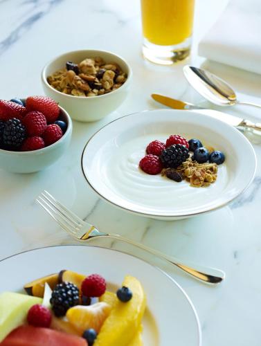 a table with two plates of fruit and a bowl of nuts at Park Hyatt Sydney in Sydney