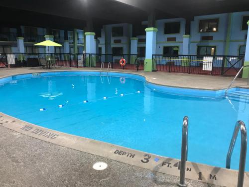 a large blue swimming pool in front of a building at Quality Inn in Vincennes