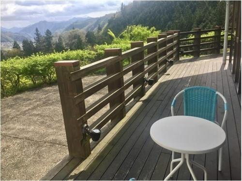 a wooden deck with a table and a table and chair at Green Spa Tsutsuga in Akiota