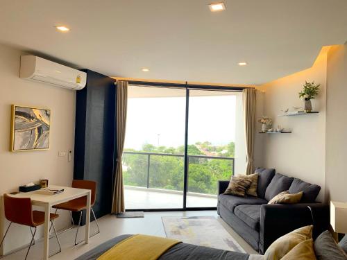a living room with a couch and a table at Top Floor Gorgeous Sunset View - Mae Phim Beachfront Condo in Mae Pim