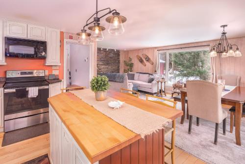 een keuken en een woonkamer met een tafel en stoelen bij Classic Stowe Ski Chalet chalet in Stowe