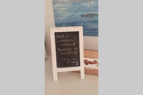 a chalkboard sign in a room with a painting at Sapphire Beach Pet Friendly Beach 5 minute walk in Sapphire Beach
