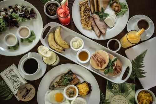 a table with plates of breakfast food on it at Malagos Garden Resort in Davao City