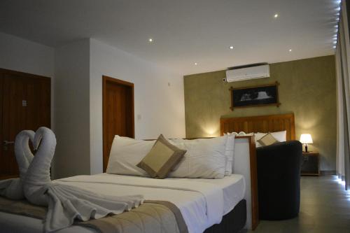 a hotel room with a bed with a swan laying on it at Lotus Lake Residence in Kandy