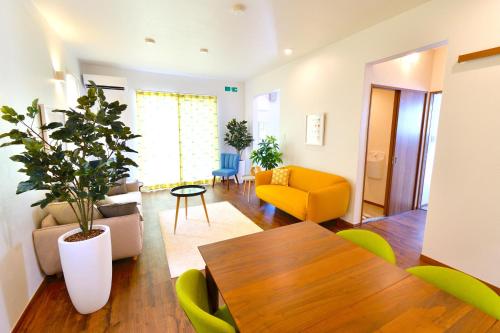 uma sala de estar com uma mesa e um sofá amarelo em Annex B Onna em Onna