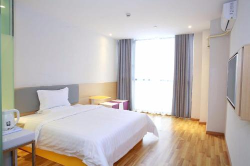 1 dormitorio con cama blanca y ventana grande en 7 Days Guiyang North Station, en Guiyang