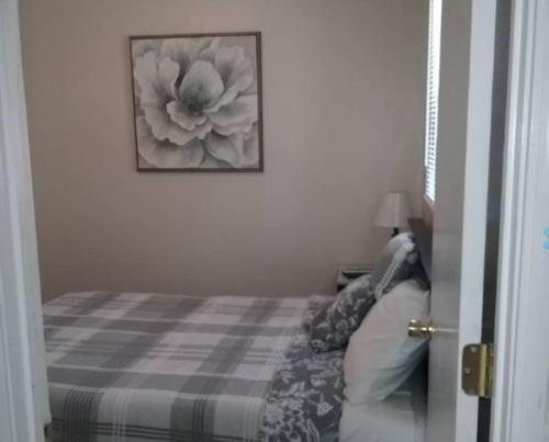 a bedroom with a bed with a flower picture on the wall at Cozy 1 BR Efficiency Apt close to TTU and Downtown in Cookeville