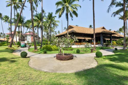 a resort with palm trees and a building at Eskala Hotels and Resorts in Ngwesaung