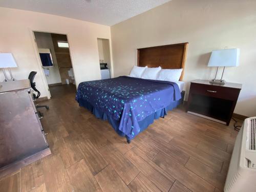 Habitación de hotel con cama, escritorio y lámpara en Coral Roc Motel, en Florida City